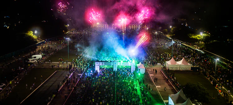 Corredores concentrados na largada de uma prova de corrida organizada pela Iguana Sports, com destaque para a Praça Charles Müller, no Pacaembu