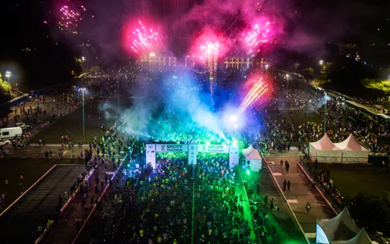 Corredores concentrados na largada de uma prova de corrida organizada pela Iguana Sports, com destaque para a Praça Charles Müller, no Pacaembu